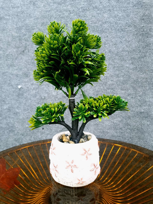 Artificial green plant in a decorative pot on a textured surface