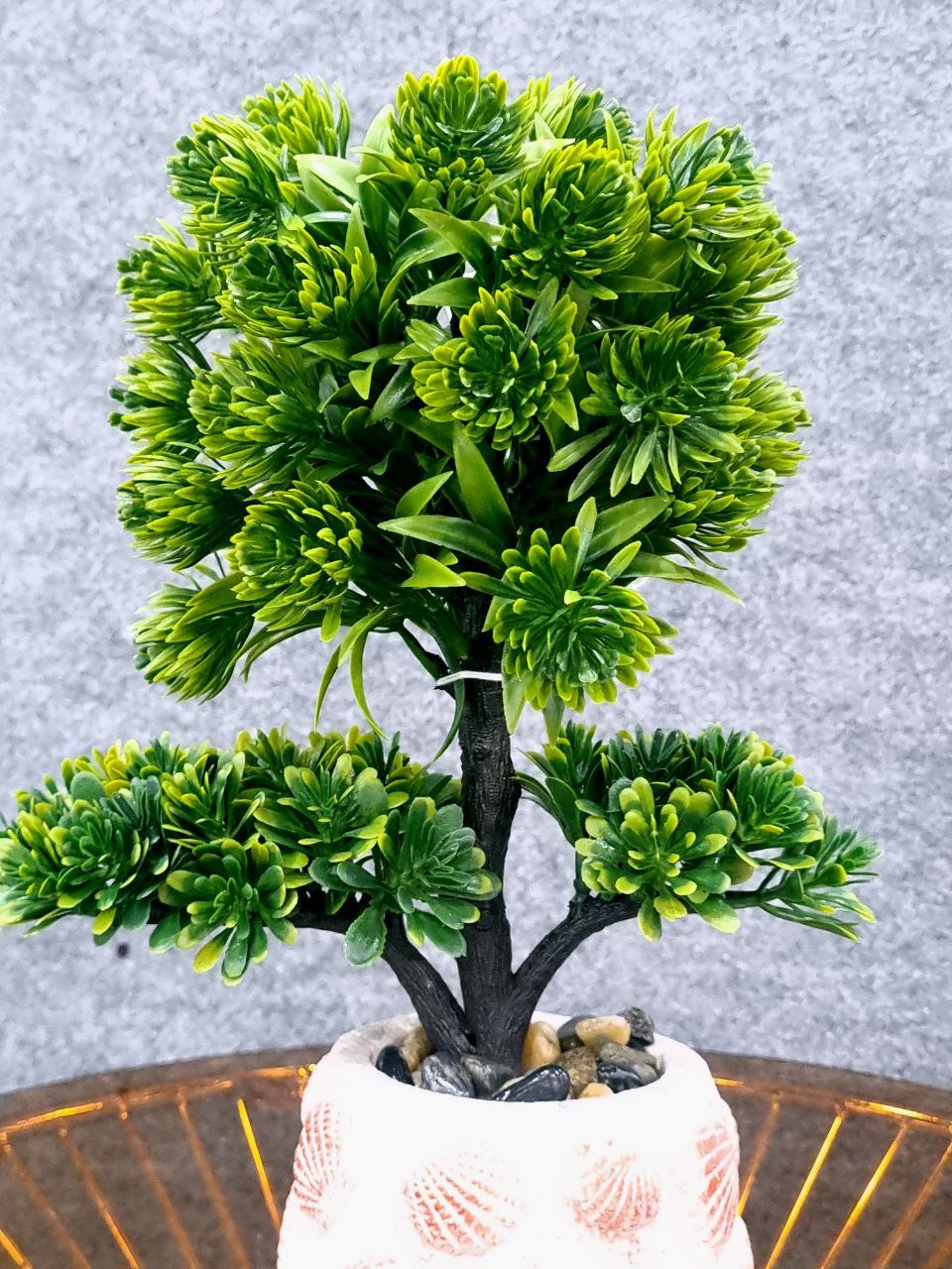 Artificial green plant in a decorative pot on a textured surface